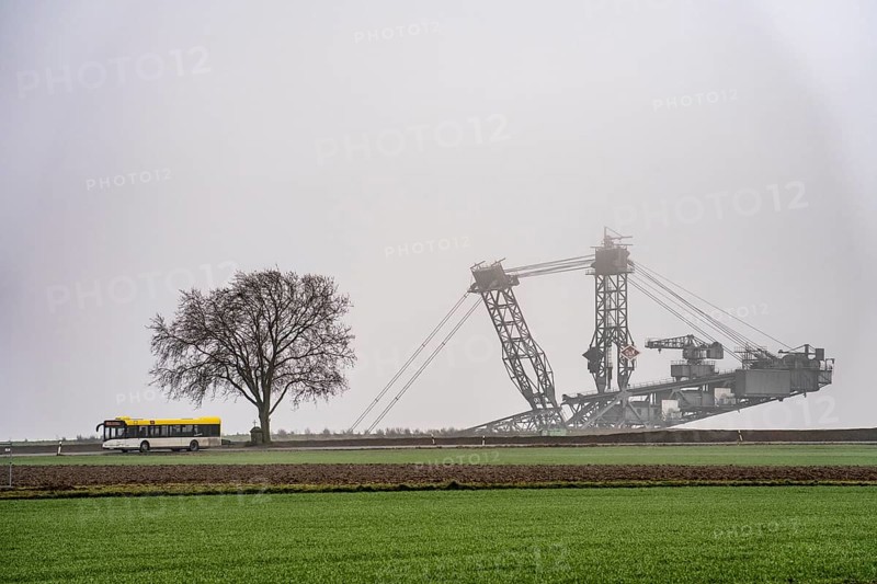 Mining excavator at the Garzweiler II open-cast lignite mine at the former, demolished village of Lützerath, on the L12 country road, in the fog, EK3 bus, North Rhine-Westphalia, Germany, Europe