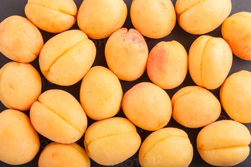 Apricots pattern on black background, top view, flat lay