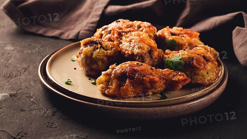 Fried chicken legs, breaded, with spices and herbs, on a dark background, horizontal, no people, selective focus, toned