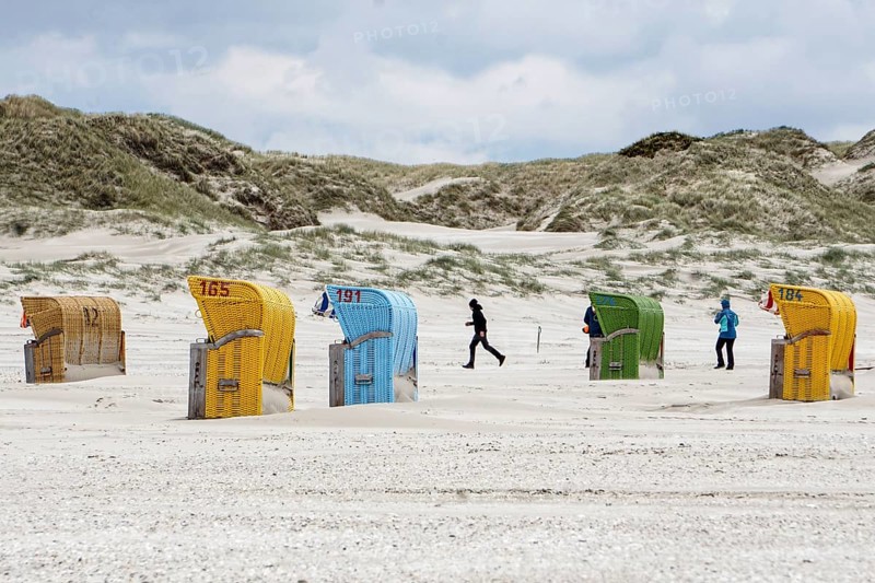 Holidaymakers walk past beach chairs on the beach of Süddorf, Insel amrum, 27.05.2021
