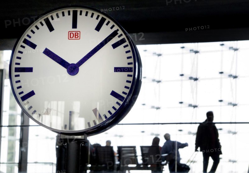 Large station clock, Deutsche Bahn passengers sitting on a bench at Berlin Central Station, 26/09/2016
