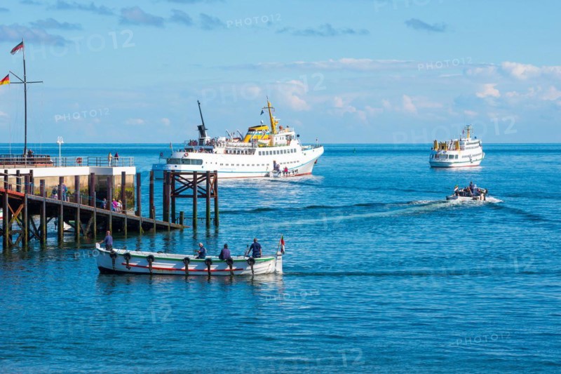 Two white ferries, 'Fair Lady' and 'Lady von Büsum', embarking, embarking off the island of Helgoland, 2 boats, traditional boat, boats with people on the open sea under blue sky, calm blue water, wooden pier, sunny day, Schleswig-Holstein, Germany, Europe