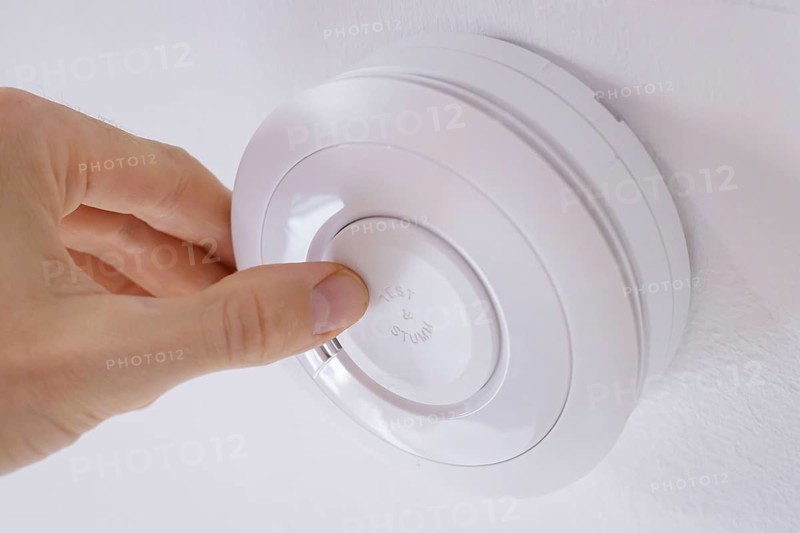 Symbolic photo on the subject of smoke alarms. A smoke detector hanging from the ceiling in a flat. Berlin, 21.08.2024