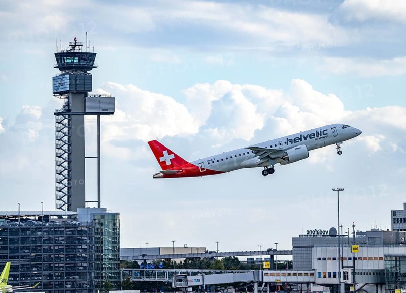 Helvetic Airways, Embraer E190-E2, HB-AZD, on take-off at Düsseldorf International Airport, air traffic control tower