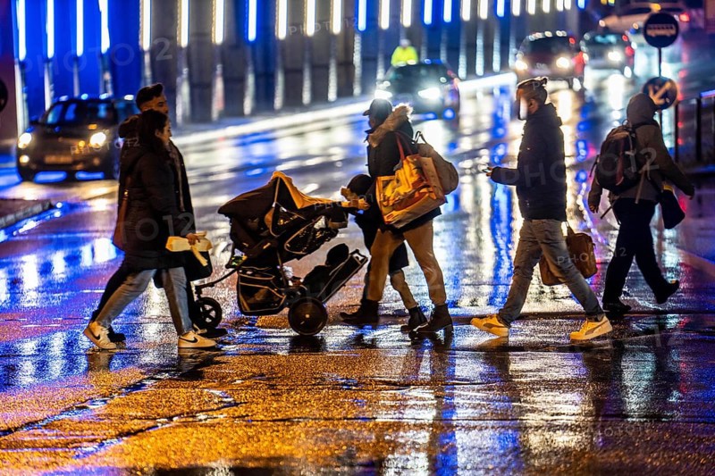 Illuminated subway at the main railway station, pedestrians at a pedestrian crossing, rainy weather, city centre, in the evening, Essen, North Rhine-Westphalia, Germany, Europe