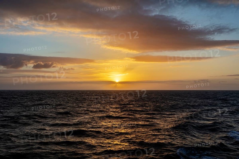 Peaceful sunset over the sea with bright orange sky and clouds, Celtic Sea