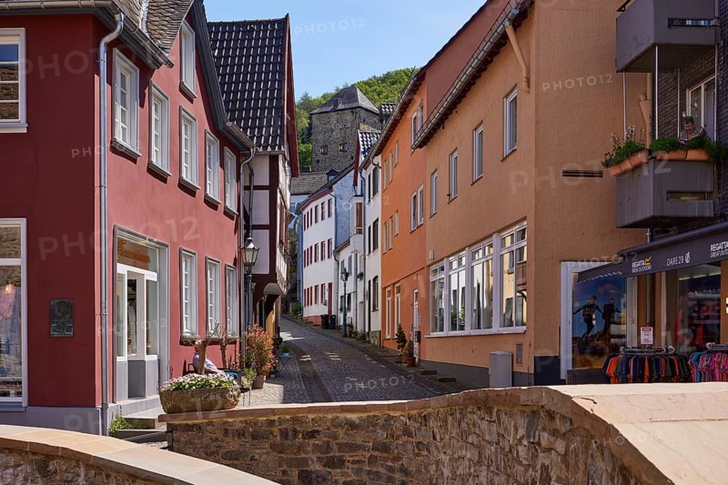 Sandstone walls and a street with various houses in the town centre of Bad Münstereifel, Eifel, Euskirchen district, North Rhine-Westphalia, Germany, Europe