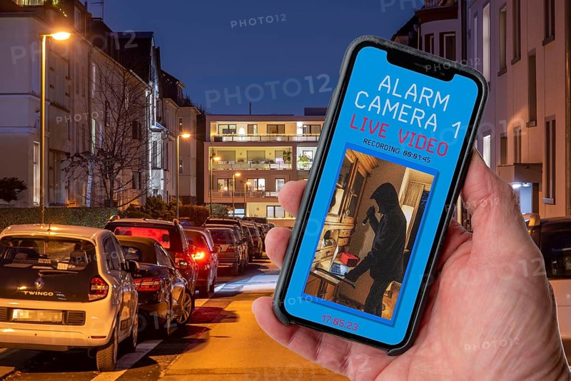 Symbolic image of burglary, burglary video app, shows the live image from a flat while a burglar is in the rooms, video camera transmits the image live to the mobile phone and records the images, motion detector triggers the camera and immediately sends a push message to the mobile phone, North Rhine-Westphalia, Germany, Europe