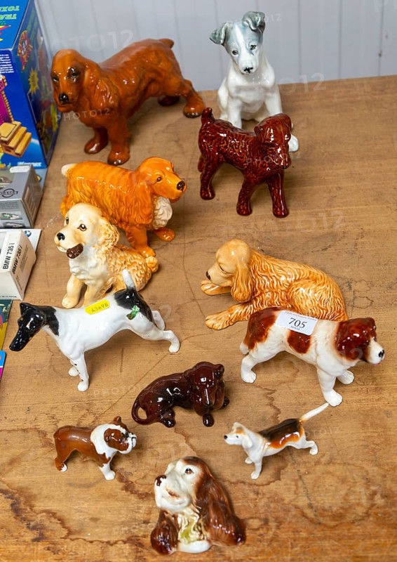 Variety of China dog models of different breeds on display as a lot in auction room, UK