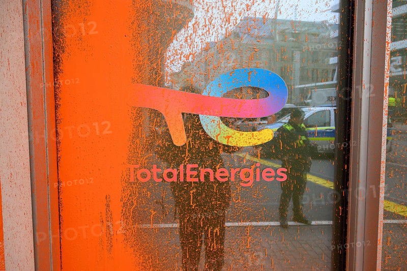 Company logo on the Total Energies building after the Last Generation colour attack. The police are reflected in the window pane. Berlin, 06.11.2024