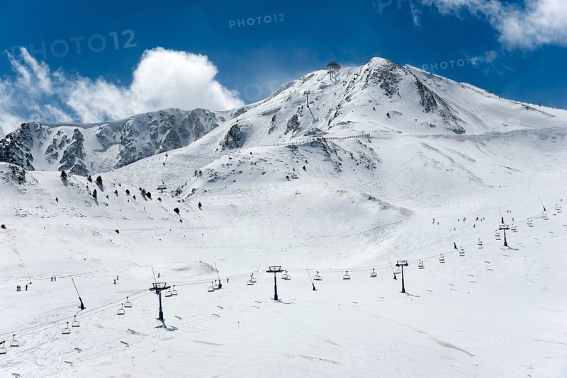 Schneebedeckte Berge unter blauem Himmel, mit Skiliften und einigen Skifahrern auf den Pisten, Skigebiet, Landschaft bei El Pas de la Casa, Pyrénées-Orientales, Encamp, Fürstentum Andorra, Pyrenäen