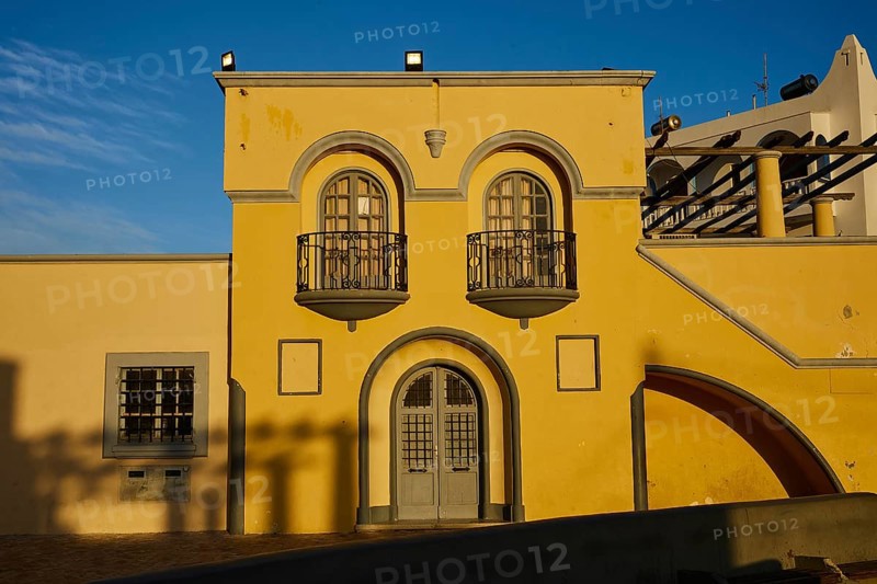 Yellow building with decorative balconies and large windows, illuminated by the last evening light, town hall, Dimarchio, Pigadia, town and harbour, Pigadia Bay, main town, Karpathos, Dodecanese, Greek Islands, Greece, Europe