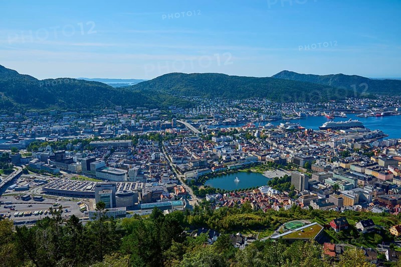 Panoramic view of a coastal town with harbour and a variety of buildings, surrounded by mountains and water under a clear sky, Fløibanen mountain station, Bergen, Vestland, Norway, Europe