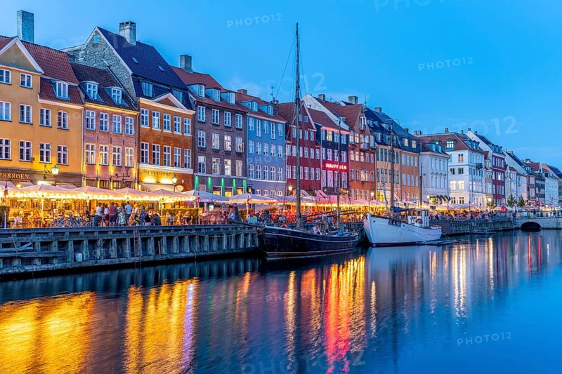 Colourful houses, restaurants and historic ships on the Nyhavn canal and harbour at dusk, Copenhagen, Denmark, Europe