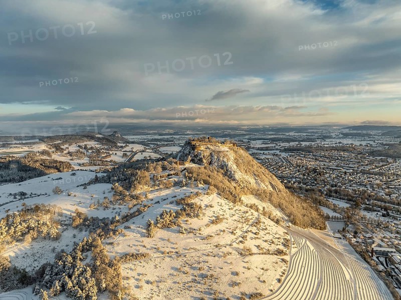 Aerial view of the snow-covered Hegau volcano Hohentwiel with Germany's largest castle ruins on a winter morning at sunrise, in front of it Germany's highest vineyard, the Elisabethenberg at 505 metres above sea level, on the right the town of Singen, on the left on the horizon the neighbouring Hegau volcano Hohenkrähen, district of Constance, Baden-Württemberg, Germany, Europe