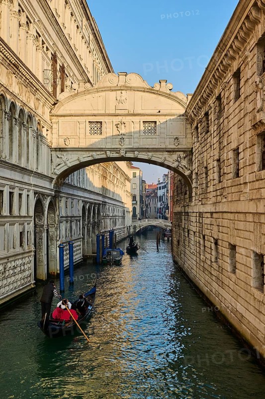 View from 'Ponte della paglia' on the bridge 'Bridge of Sighs' over a waterway on a sunny morning with gondolier in Venice on a foggy morning in winter, Italy, Europe