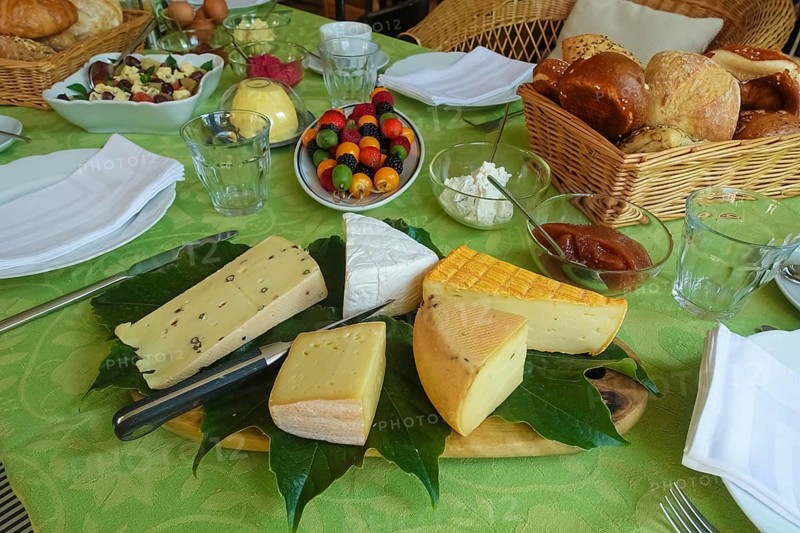 Cheese platter with different types of cheese, hard cheese, fruit skewers arranged on serving platter, raspberries, blackberries, kiwi, physalis, bladder cherries, healthy, vegetarian, fruit, vitamins, fruit salad with citrus fruits and cheese, crockery, bread basket, bread rolls, cream cheese, butter, fruit jelly, food, breakfast table, brunch, table setting, food, studio, Germany, Europe