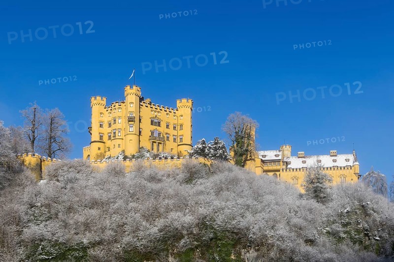 A castle majestically enthroned on a snow-covered hill with a blue sky, Hohenschwangau Castle, Schwangau, Königswinkel, Ostallgäu, Allgäu, Swabia, Bavaria, Germany, Europe