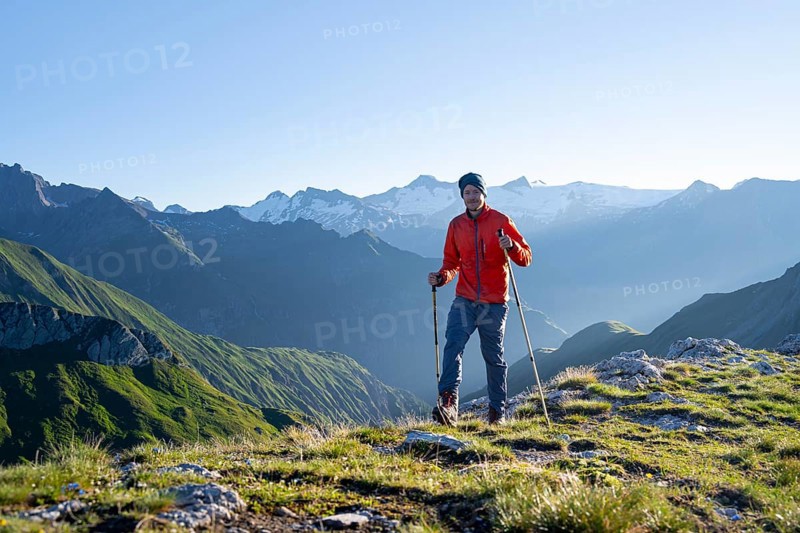 Hiker enjoying the mountain panorama in the morning, Venediger group, behind Dreiherrenkopf, Simonysitze and Großer Geiger, Hohen Tauern, Austria, Europe