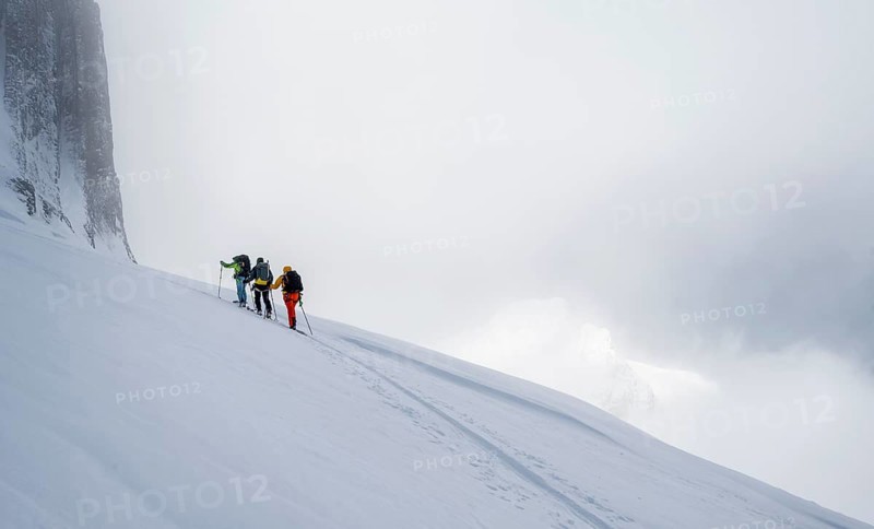 Dramatic atmosphere, Ski tourers, Snowy mountain landscape, Bernese Alps, Bernese Oberland, Switzerland, Europe