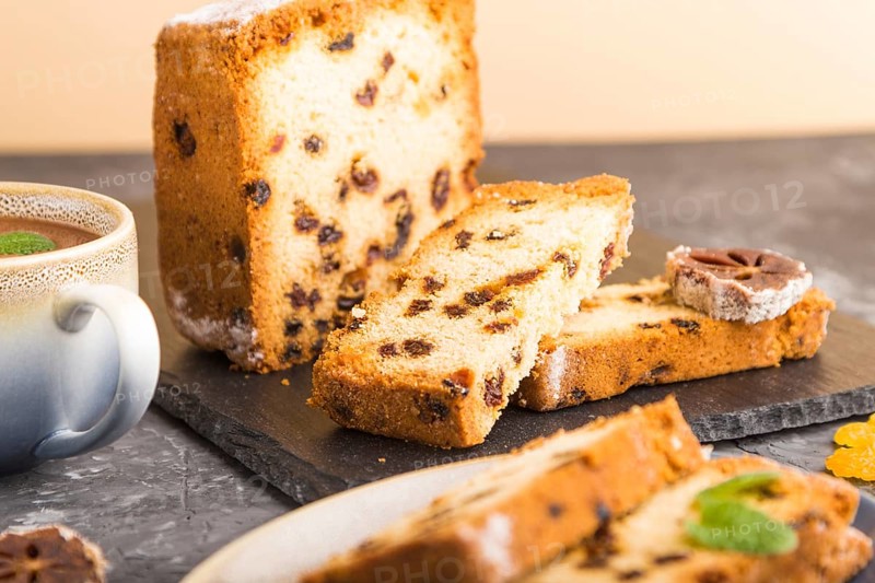 Homemade cake with raisins, dried persimmon and a cup of hot chocolate on a black concrete background. Side view, close up, copy space, selective focus
