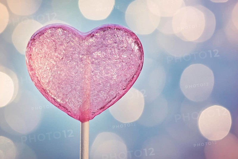 Pink heart shaped Valentine's Day lolli in front of background with bokeh lights. Generative AI, AI generated