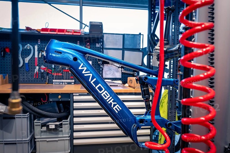 Blue bicycle frame in a workshop with tools in the background, Waldbike Manufaktur, bicycle workshop, Calw, district of Calw, Black Forest, Germany, Europe