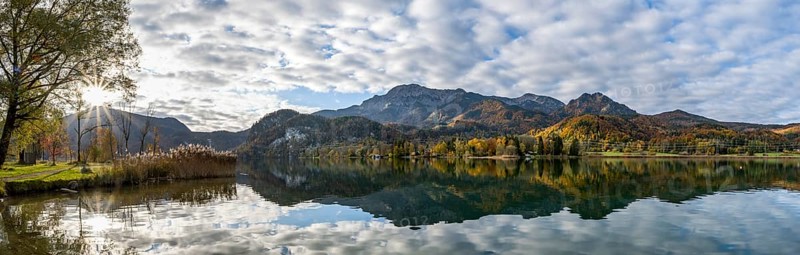 Autumnal mountain landscape with mountain peaks Herzogstand and Heimgarten, reflection in Lake Kochel, with sun star, Upper Bavaria, Bavaria, Germany, Europe