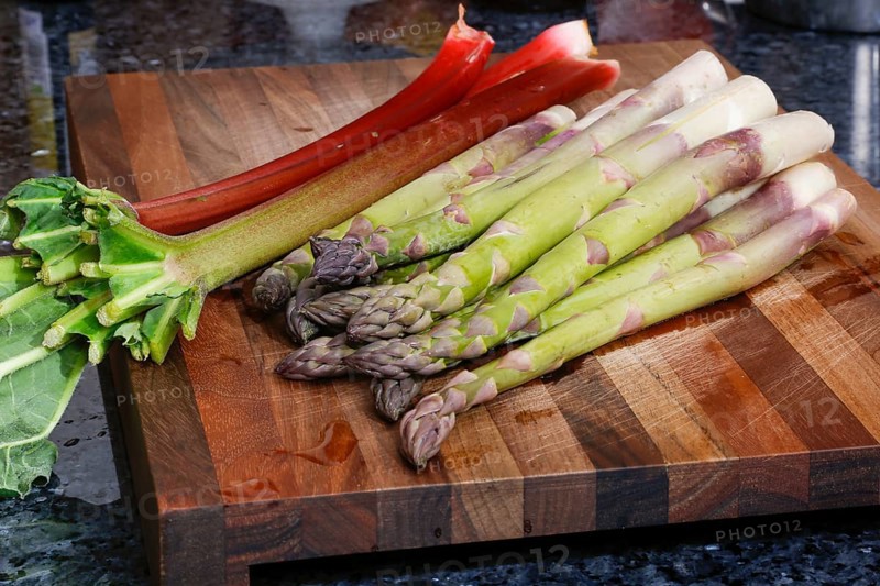 South German cuisine, vegetables, vegetarian, preparation of green asparagus with rhubarb vinaigrette and potato gratin, healthy, raw asparagus on wooden board, cutting board, rhubarb, traditional cuisine reinterpreted, food photography, studio, Germany, Europe