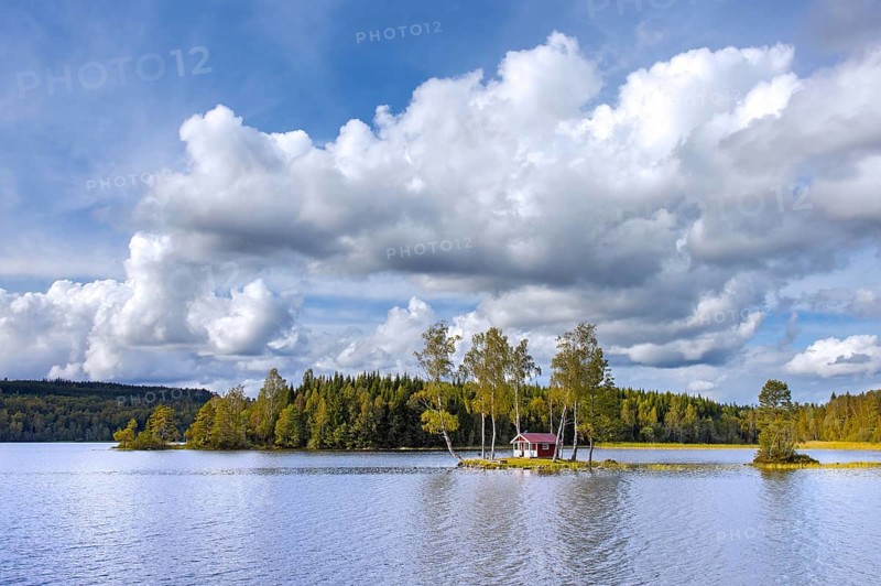 Small traditional red wooden cabin on tiny island in lake in autumn, fall, Värmland, west-central Sweden, Scandinavia