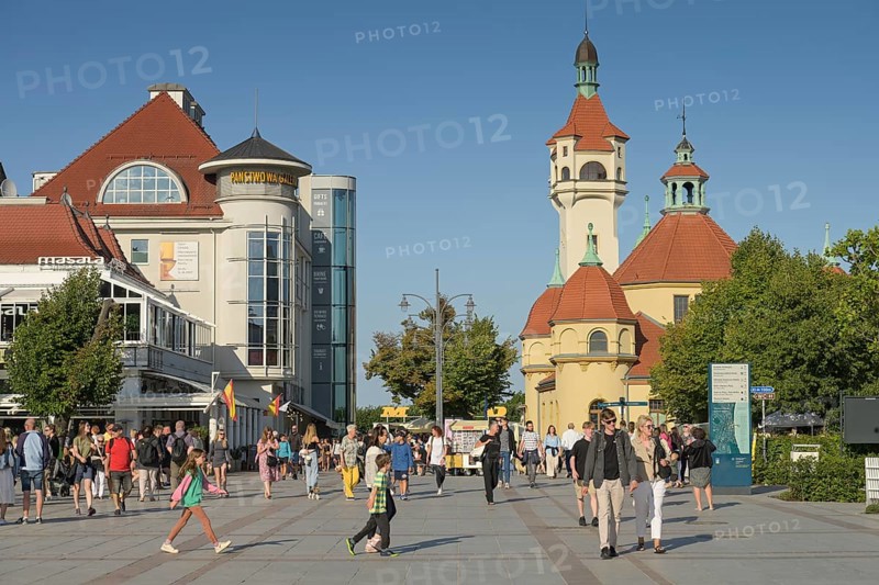 Holidaymakers on the square Plac Przyjaciol Sopotu, at the back right lighthouse, Latarnia Morska w Sopocie with thermal bath, Zaklad Balneologiczny, Sopot, Pomeranian Voivodeship, Poland, Europe