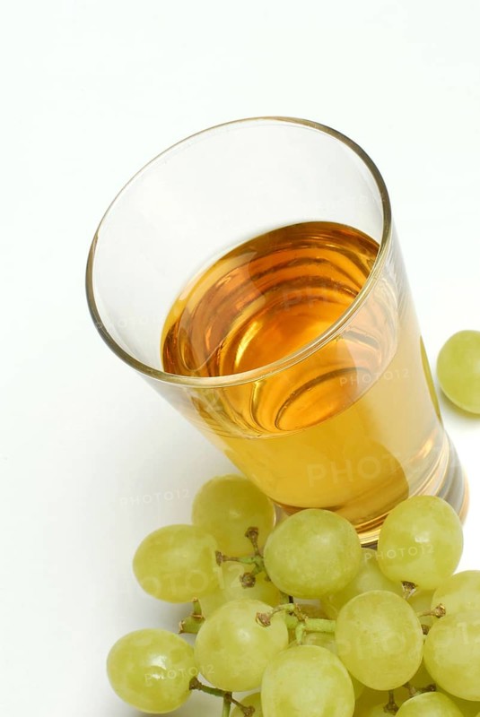 White grape juice in glass, grapes