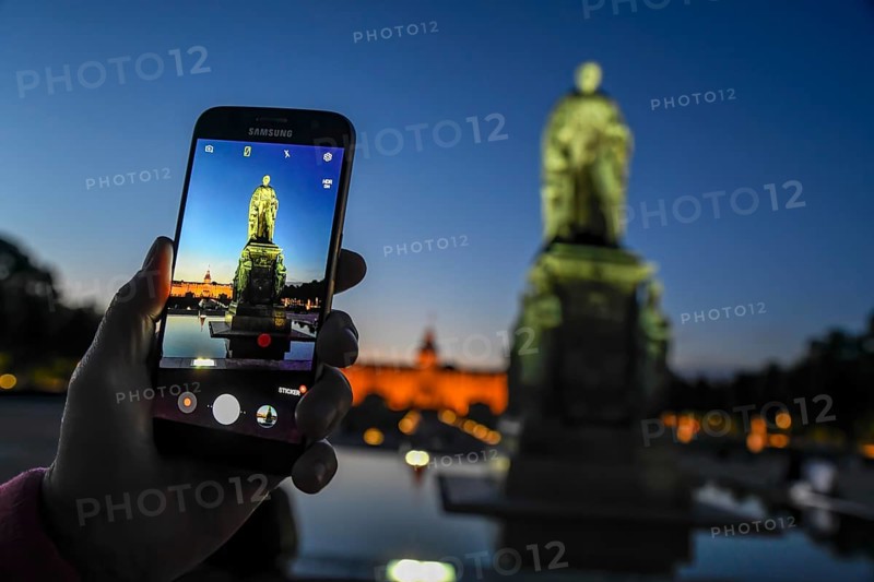 Monument of the Grand Duke Karl Friedrich von Badenon the display of the mobile phone, Schlossplatz, in the back the castle, Karlsruhe, Baden-Württemberg, Germany, Europe
