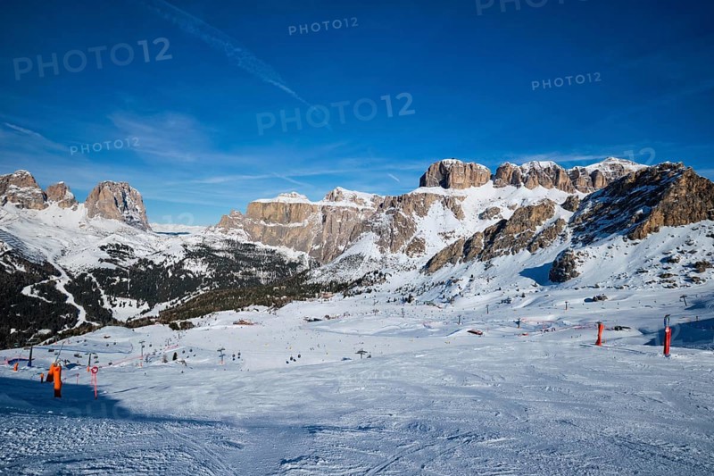View of a ski resort piste with people skiing in Dolomites in Italy. Ski area Belvedere. Canazei, Italy, Europe