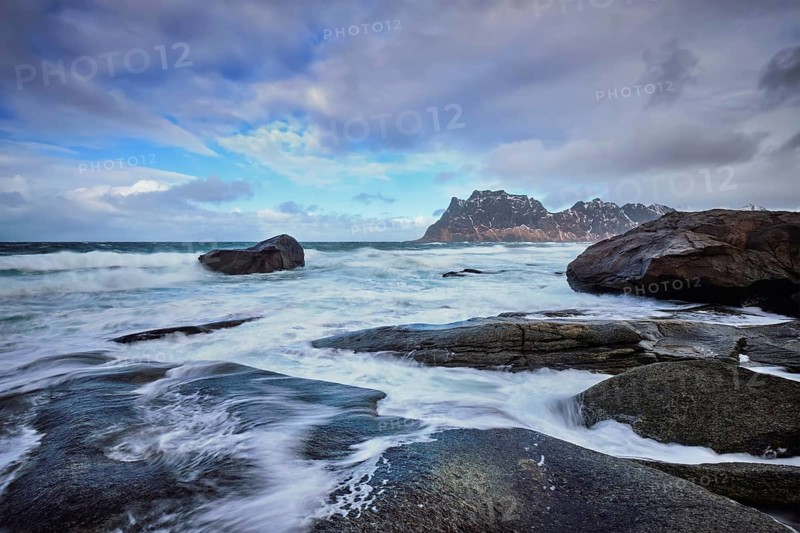 Rocks on beach of fjord of Norwegian sea in winter with snow. Utakliev beach, Lofoten islands, Norway, Europe