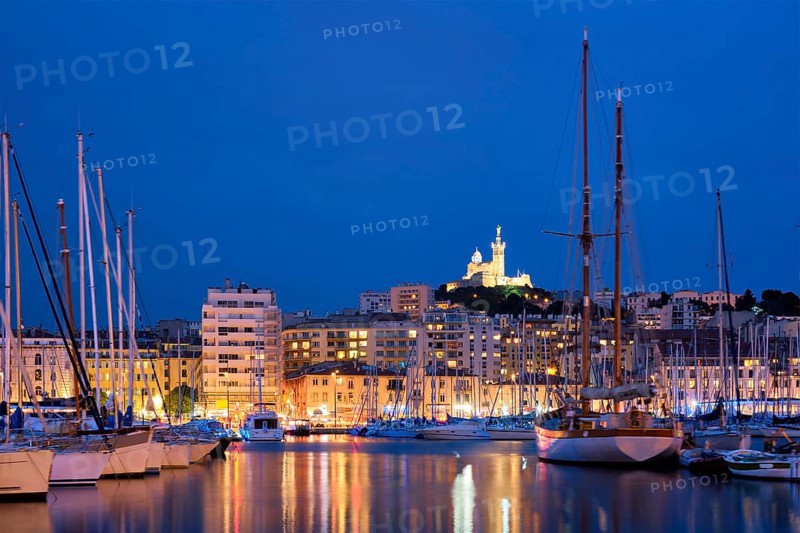 Marseille Old Port (Vieux-Port de Marseille) with yachts and Basilica of Notre-Dame de la Garde in the night. Marseille, France, Europe