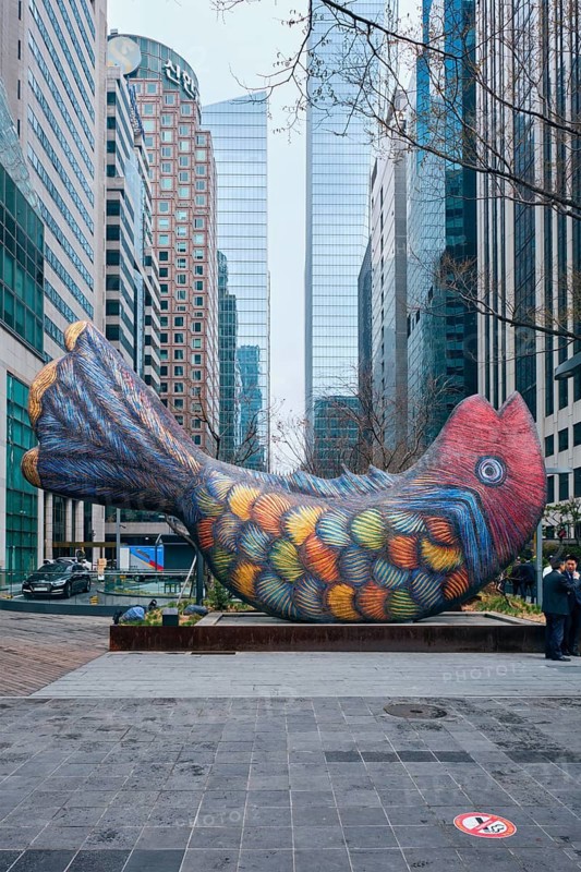 SEOUL, SOUTH KOREA, APRIL 6, 2018: Fish statue in the financial District of Seoul, South Korea with high rise skyscraper buildings in the background