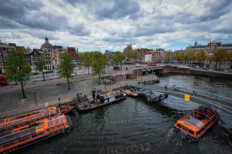 AMSTERDAM, NETHERLANDS, MAY 9, 2017: Aerial view of Amsterdam canal with tourist boats near Amsterdam Centraal