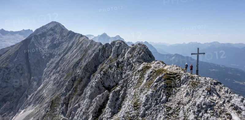 Aerial view, Alpine panorama, hikers at the summit cross, Westliche Wettersteinspitze, Wetterstein Mountains, Bavaria, Germany, Europe