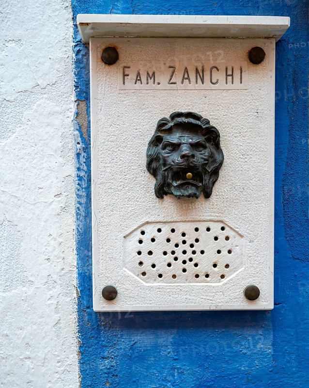 Name and doorbell button in the shape of a lion on a blue house wall, Burano Island, Venice, Veneto, Italy, Europe