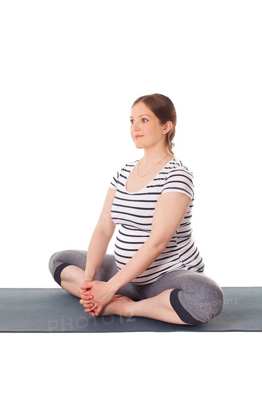 Pregnancy yoga exercise, pregnant woman doing asana Baddha Konasana Bound Angle Pose isolated on white background
