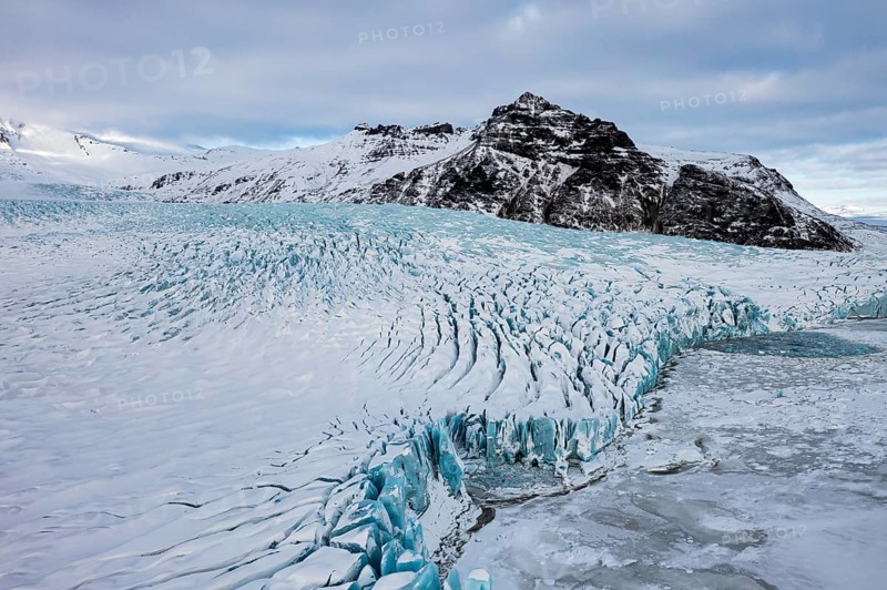 Snow-covered icebergs in the Fjallsarlon glacier lagoon, with the Öraefajökull glacier behind, drone shot, Sudurland, Iceland, Europe
