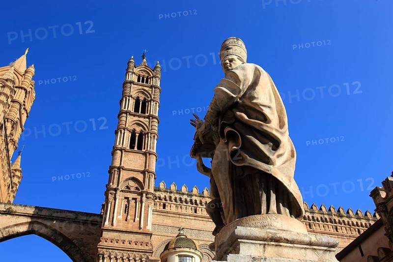 City of Palermo, the west tower at the Archbishop's Palace connected by pointed arches to the Cathedral Maria Santissima Assunta, in front of it a statue of a saint, UNESCO World Heritage Site, Sicily, Italy, Europe