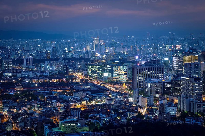 Seoul downtown cityscape illuminated with lights and Gyeongbokgung Palace in the evening view from Inwang mountain. Seoul, South Korea, Asia