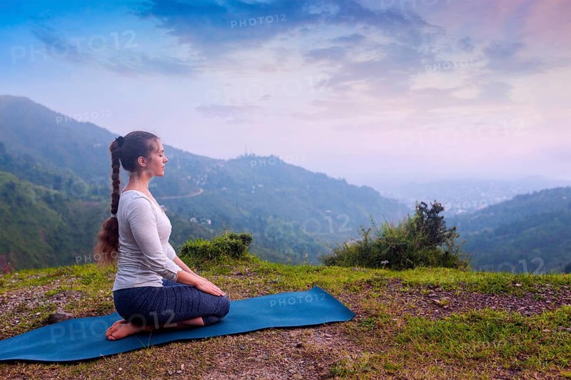 Yoga exercise outdoors, woman doing Yoga asana Virasana (Vajrasana) Hero pose in Himalayas in India on sunset