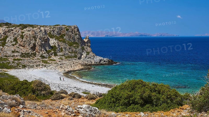 Agios Pavlos beach, pebble beach, barren rocks, trees, blue sea, green sea, Gramvoussa peninsula, two walkers on the beach, almost cloudless blue sky, single white cloud, west coast of Rodopou peninsula, west Crete, island of Crete, Greece, Europe