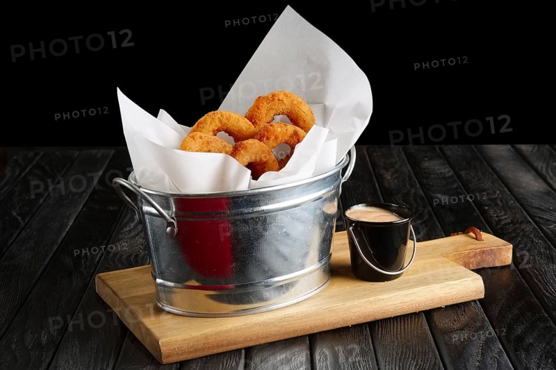 Snack for beer. Fried onion rings with sauce served in metal backet