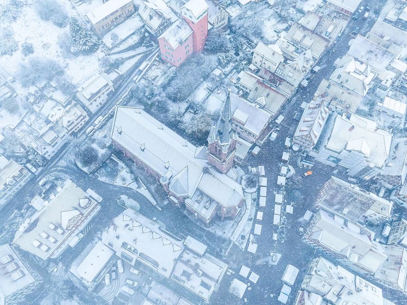 Drone image of a town covered in snow with visible streets and roofs, Black Forest, Calw, Germany, Europe