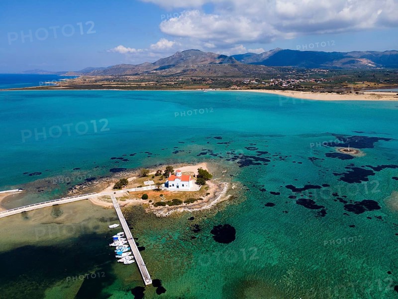 Drone shot, Greek Orthodox Church of Saint Spiridon, Agios Spyridon, Elafonisos town, Elafonisos, Deer Island, Laconia, Peloponnese, Ionian Islands, Ionian Sea, Greece, in the background Pounta and Stavros Elafonissos lighthouse, Europe