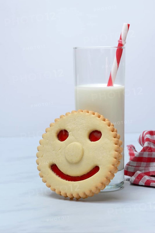 Pastry with smiley face and glass of milk